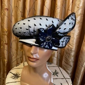 White and black pill box hat with netting covering the crown